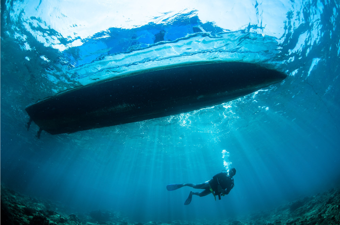 Scuba diver making a slow controlled ascent through clear blue tropical water